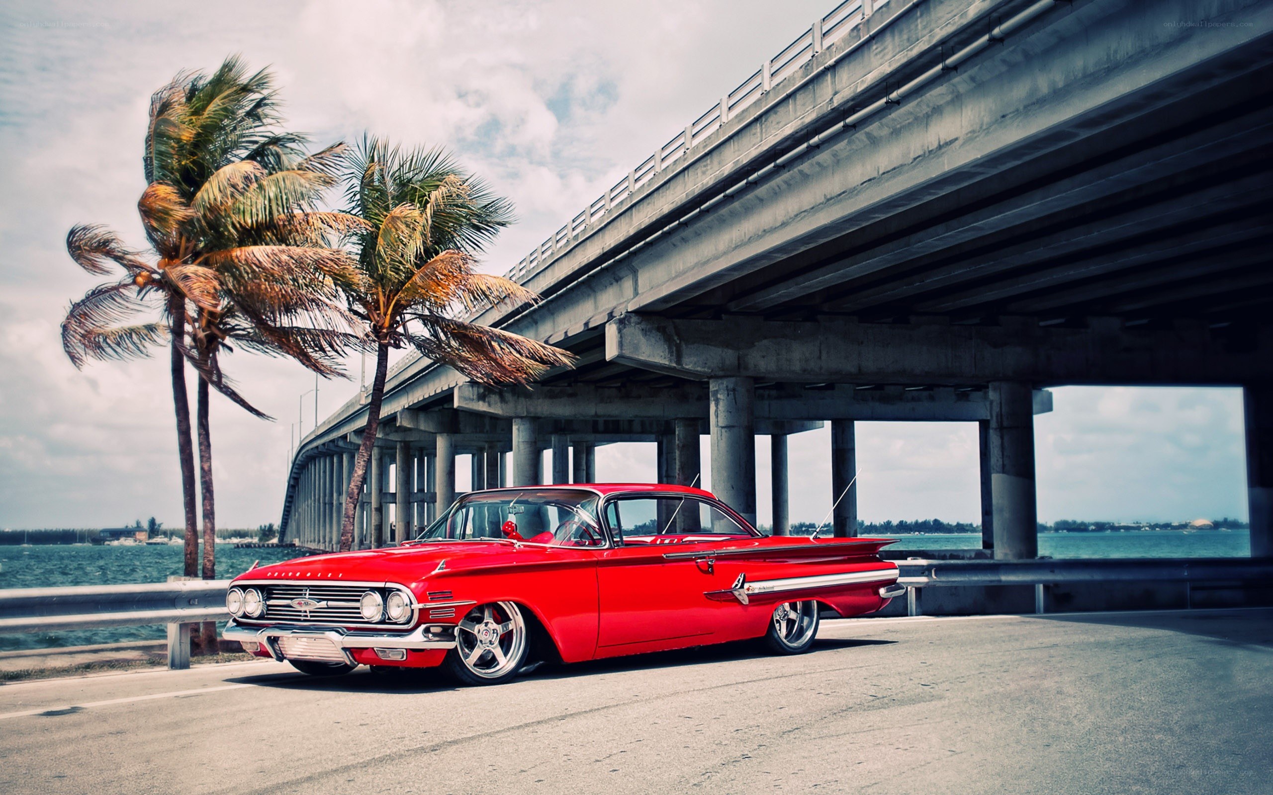 Red classic car under bridge