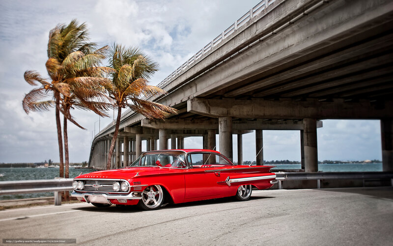 Red classic car under bridge