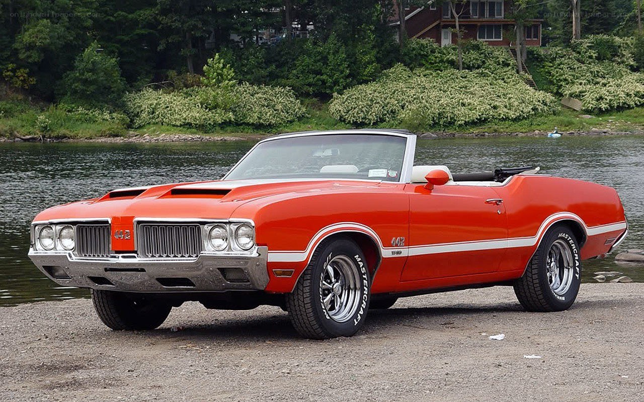Red classic convertible by the lake