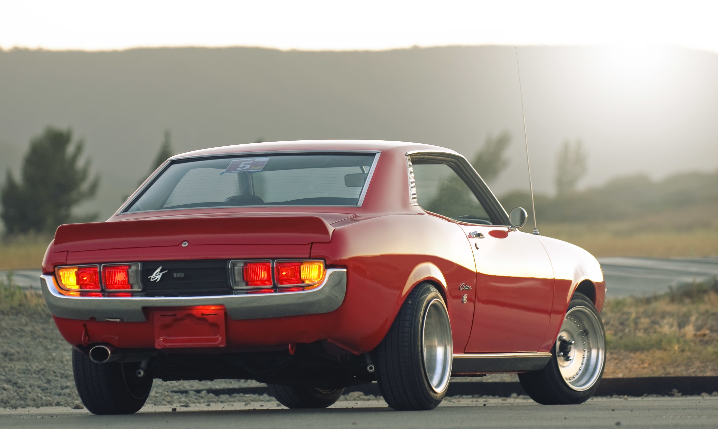 Red classic coupe on road