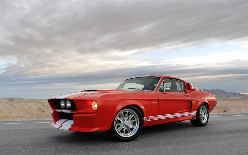 Red classic muscle car on desert road