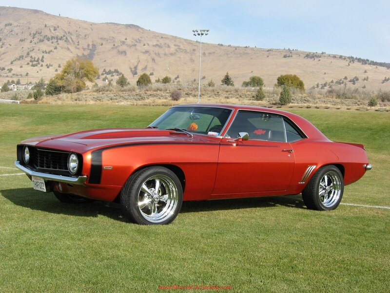 Red classic muscle car on grass