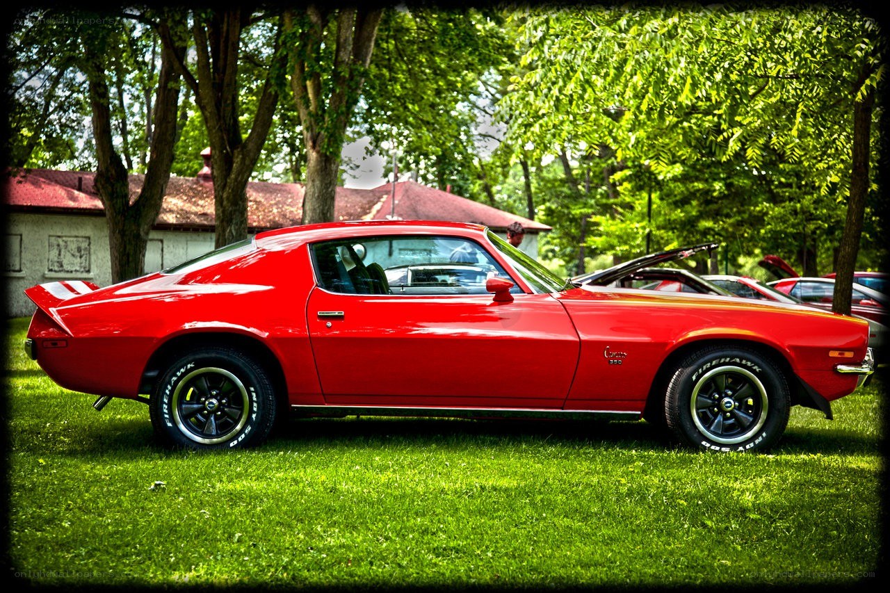 Red classic muscle car on grass