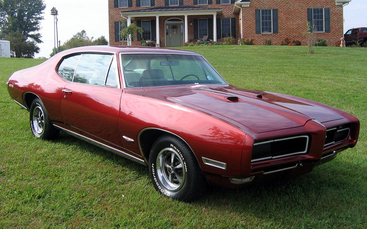 Red classic muscle car on lawn