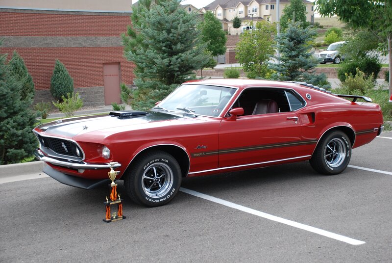 Red classic muscle car with trophy