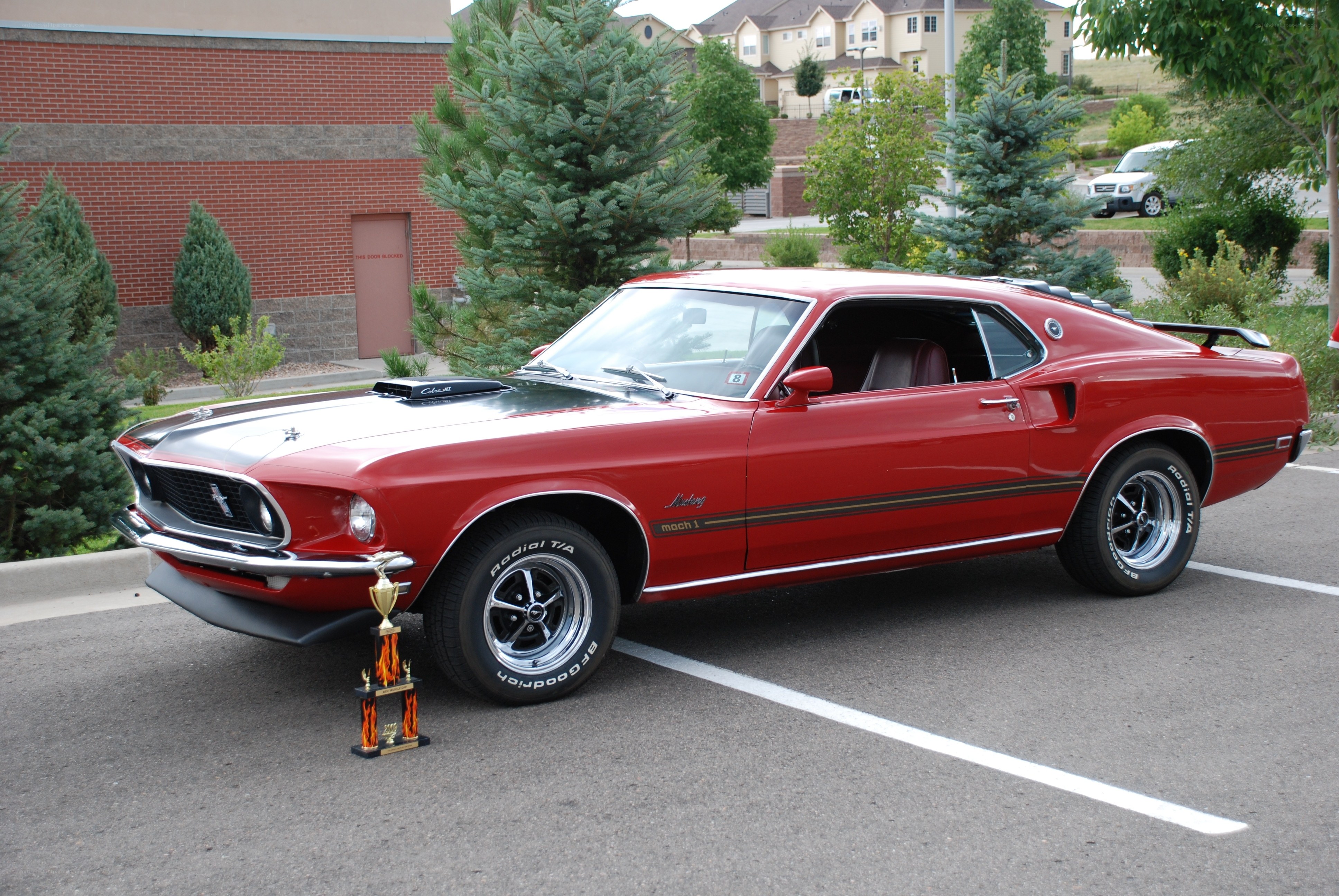 Red classic muscle car with trophy