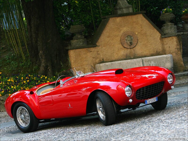 Red classic sports car on cobblestone