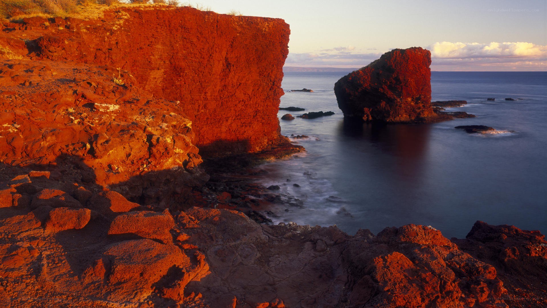Red cliffs at sunset by the sea