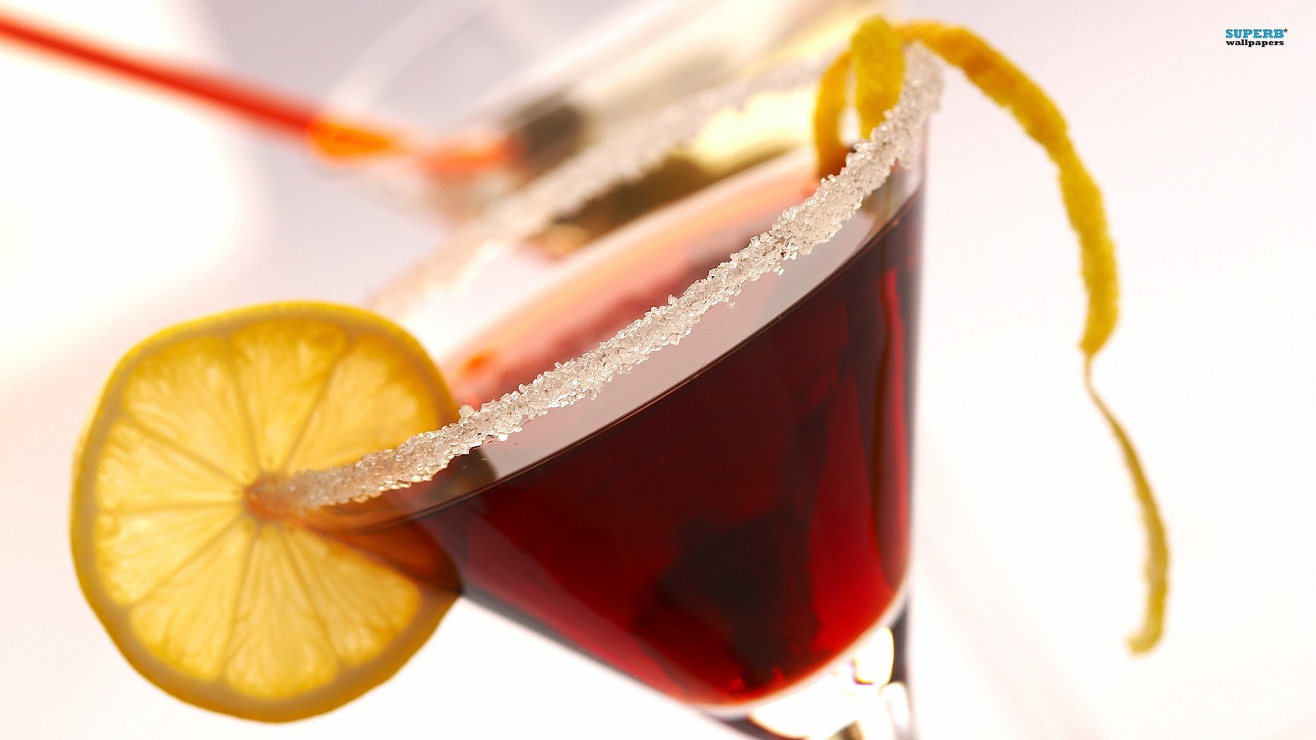 red cocktail with lemon garnish