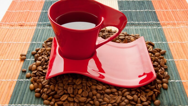 Red coffee cup on beans