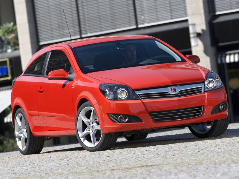 Red compact car on gravel