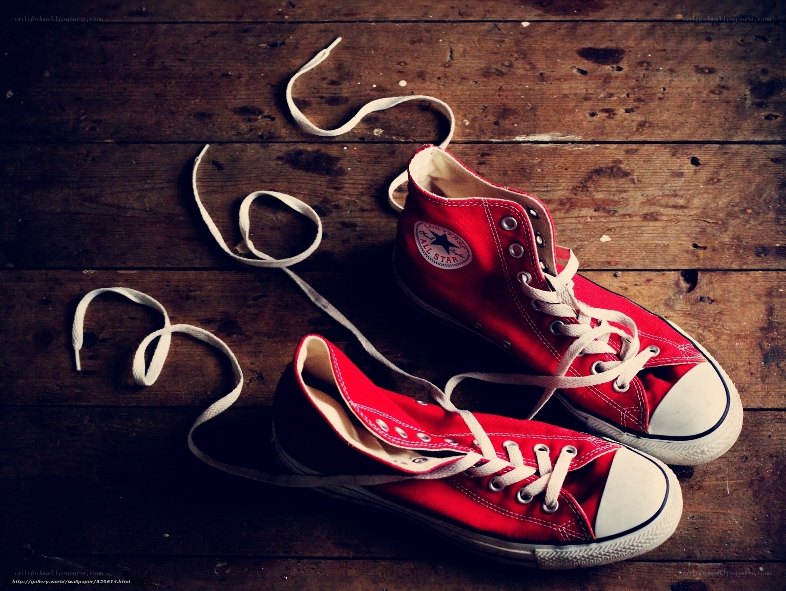 Red Converse sneakers on wood