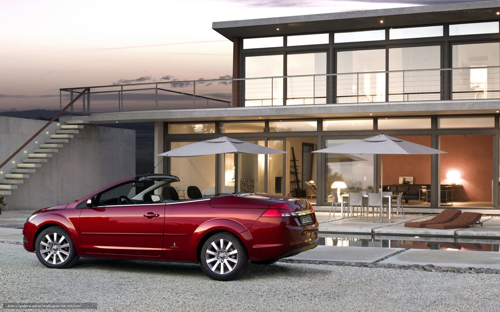 Red convertible by modern house
