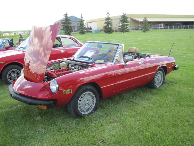 Red Convertible Car — Calm, Afternoon, Photograph, Grass Field, Building