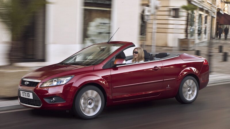 Red convertible driving in city