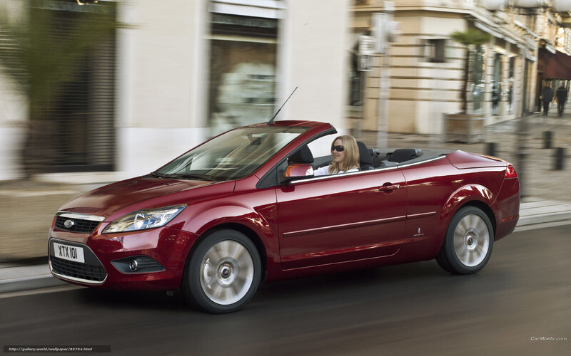 Red convertible driving in city