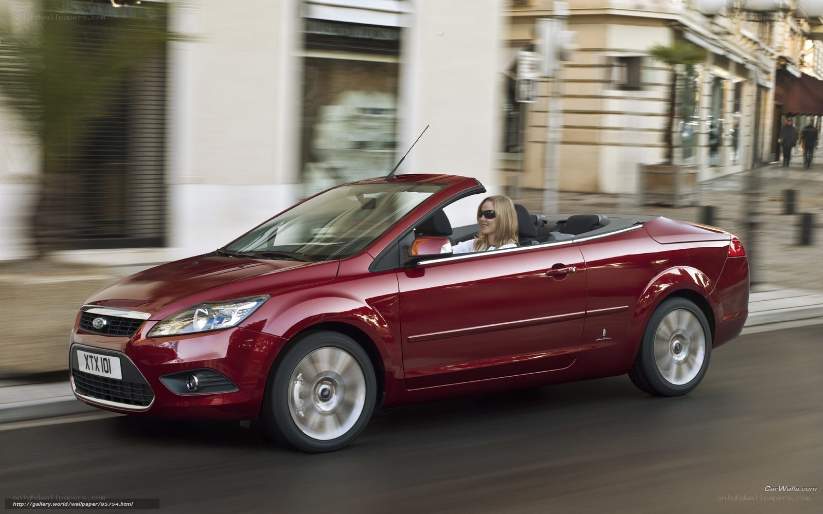 Red convertible driving in city