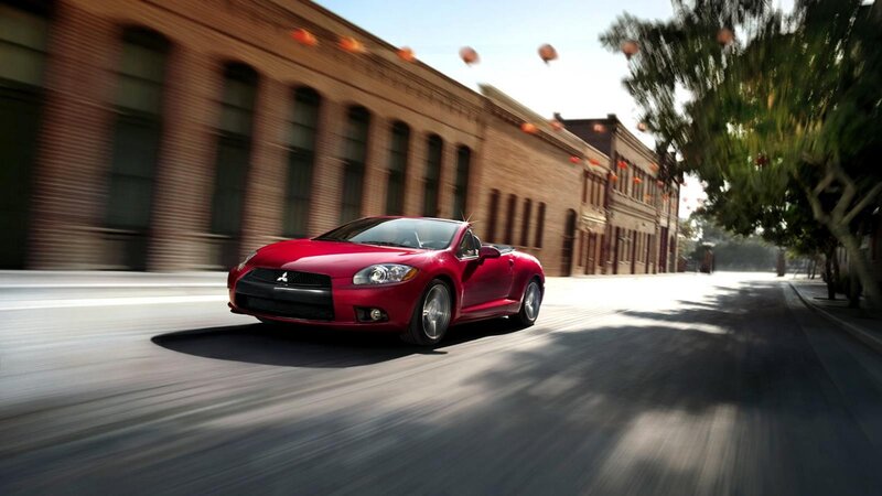 Red convertible driving on city street