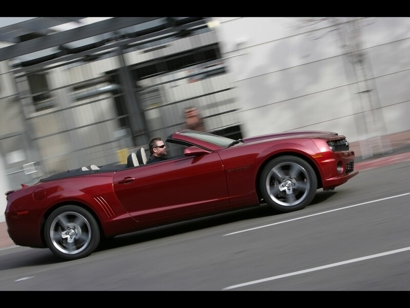 Red convertible driving on city street