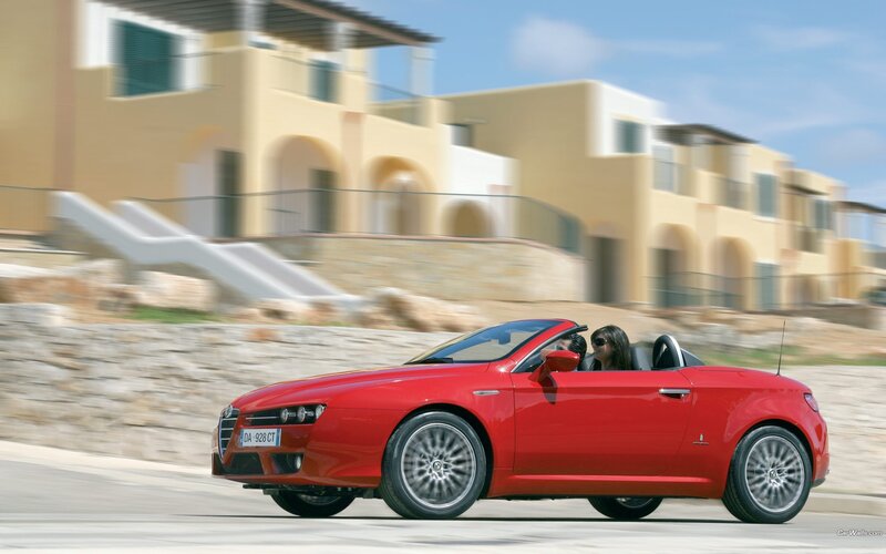 Red convertible driving on coastal road