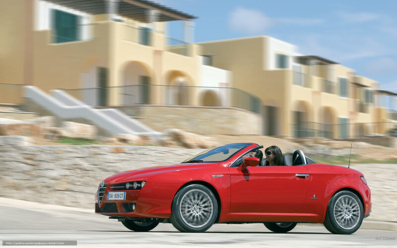 Red convertible driving on coastal road