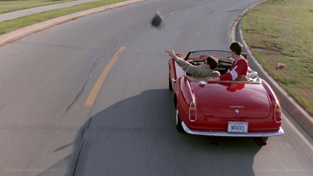 Red convertible driving on road