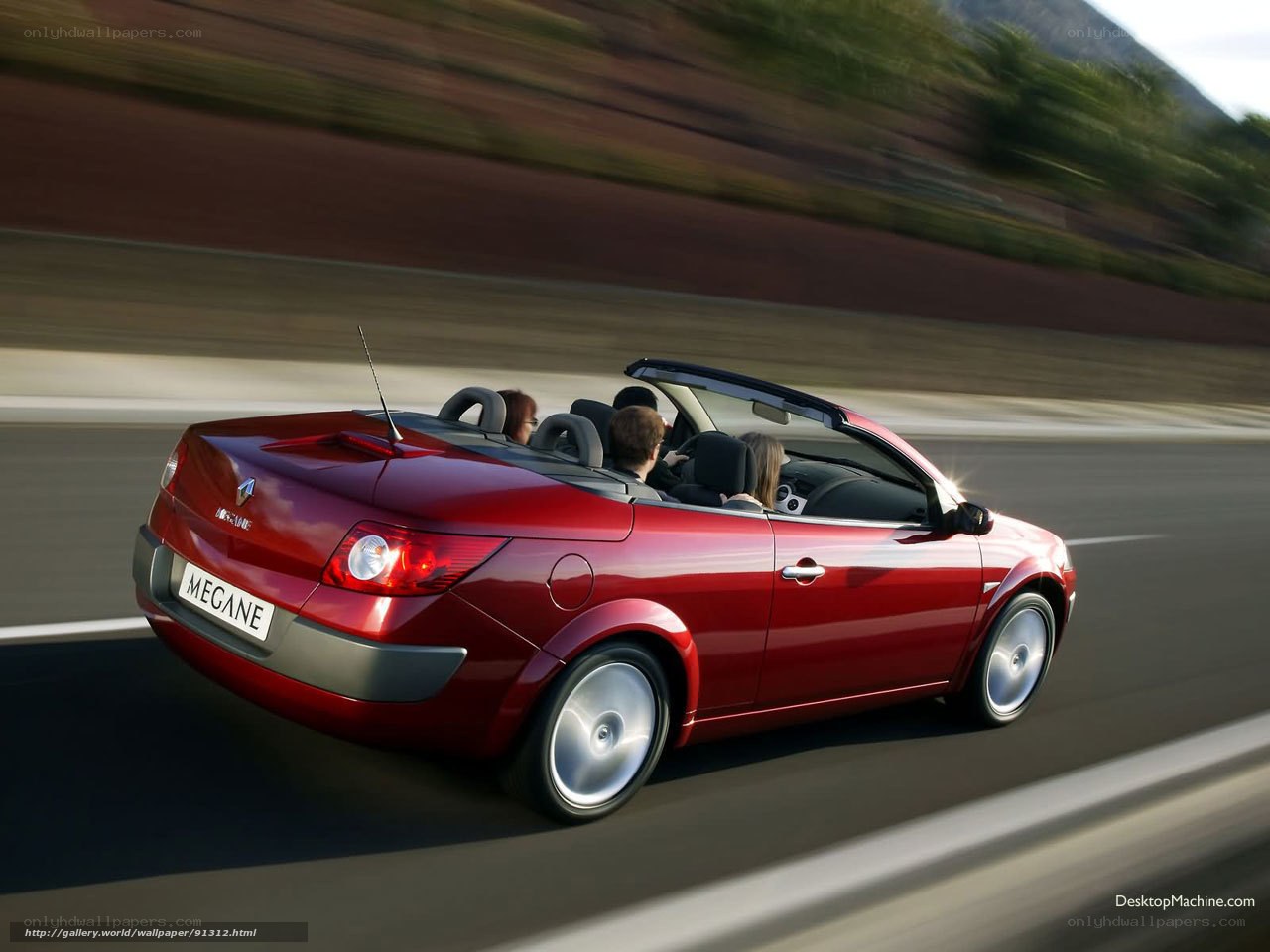 Red convertible driving on road