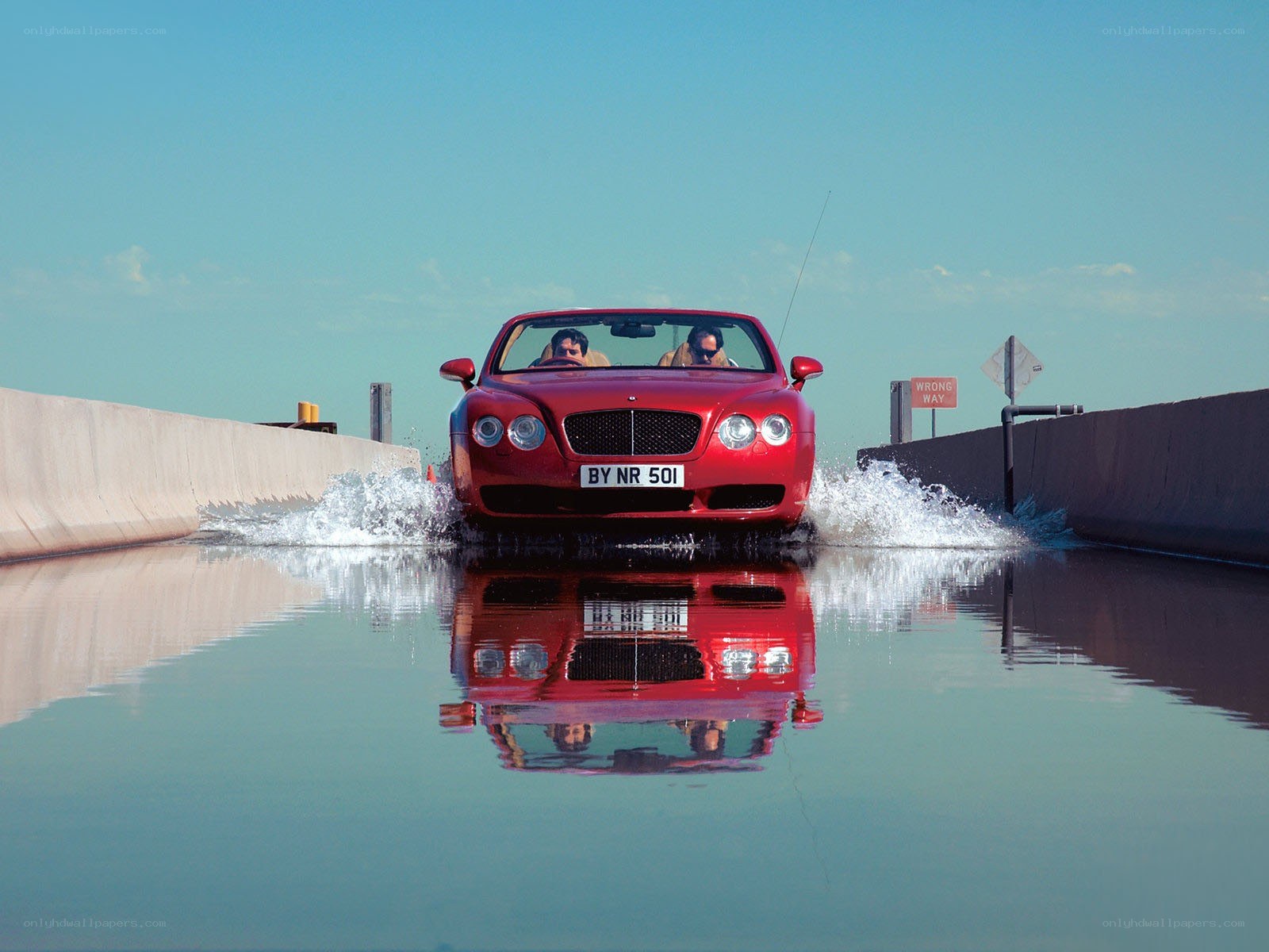 Red convertible driving through water