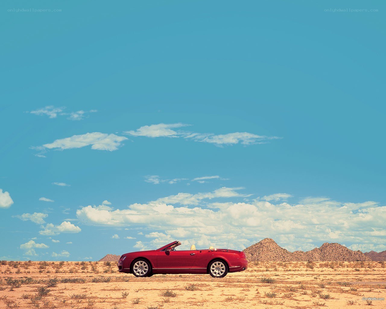 Red convertible in desert landscape