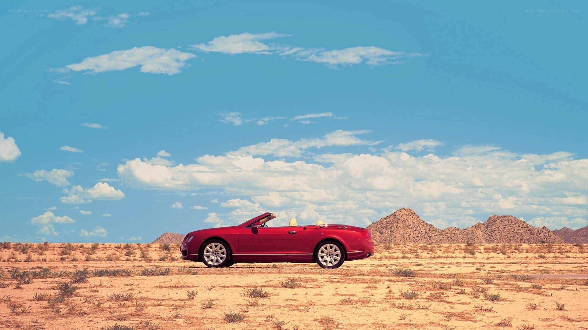 Red convertible in desert landscape
