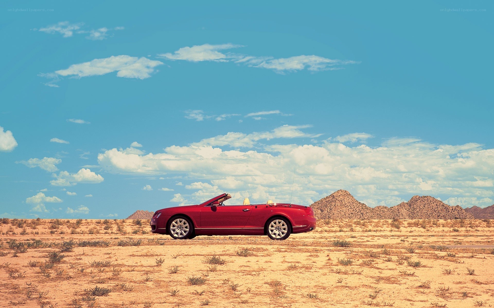 Red convertible in desert landscape
