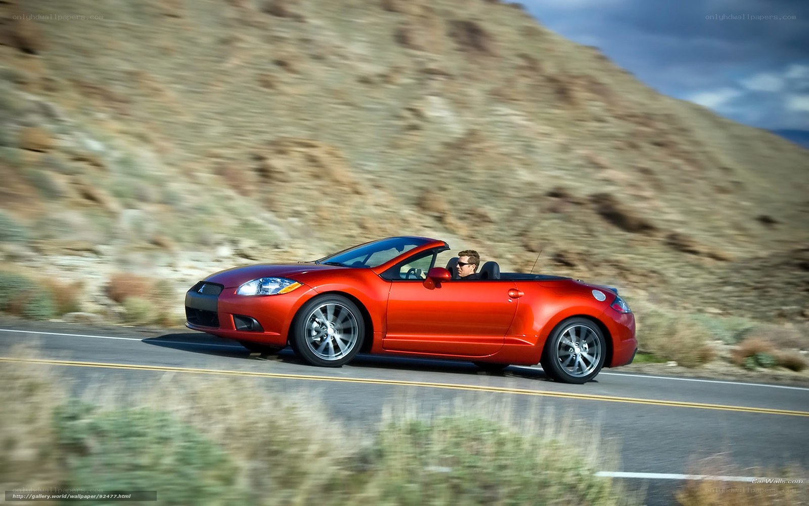 Red convertible on a scenic road