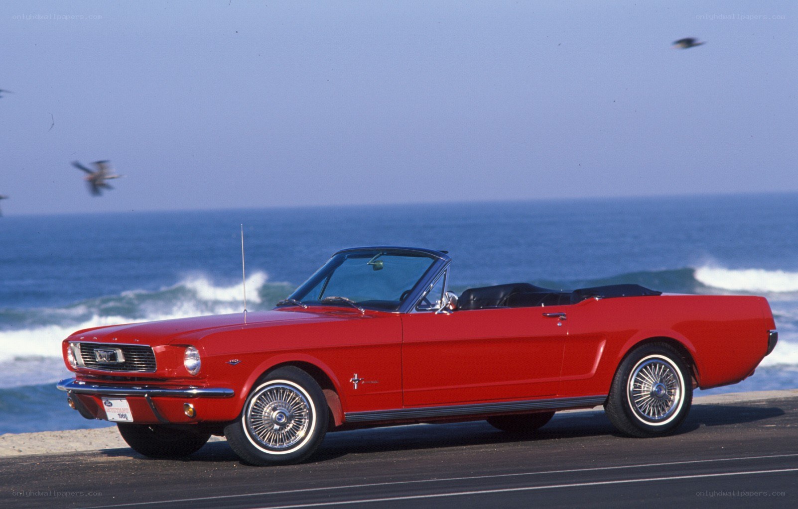 Red convertible on beach road