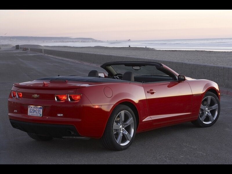 Red convertible on beach road