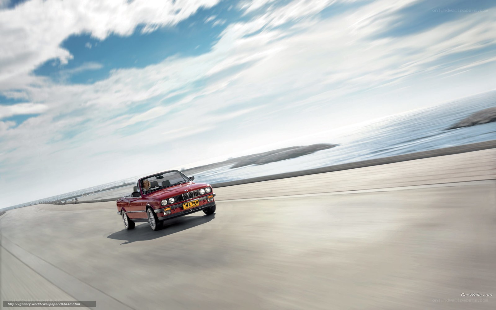 Red convertible on coastal road