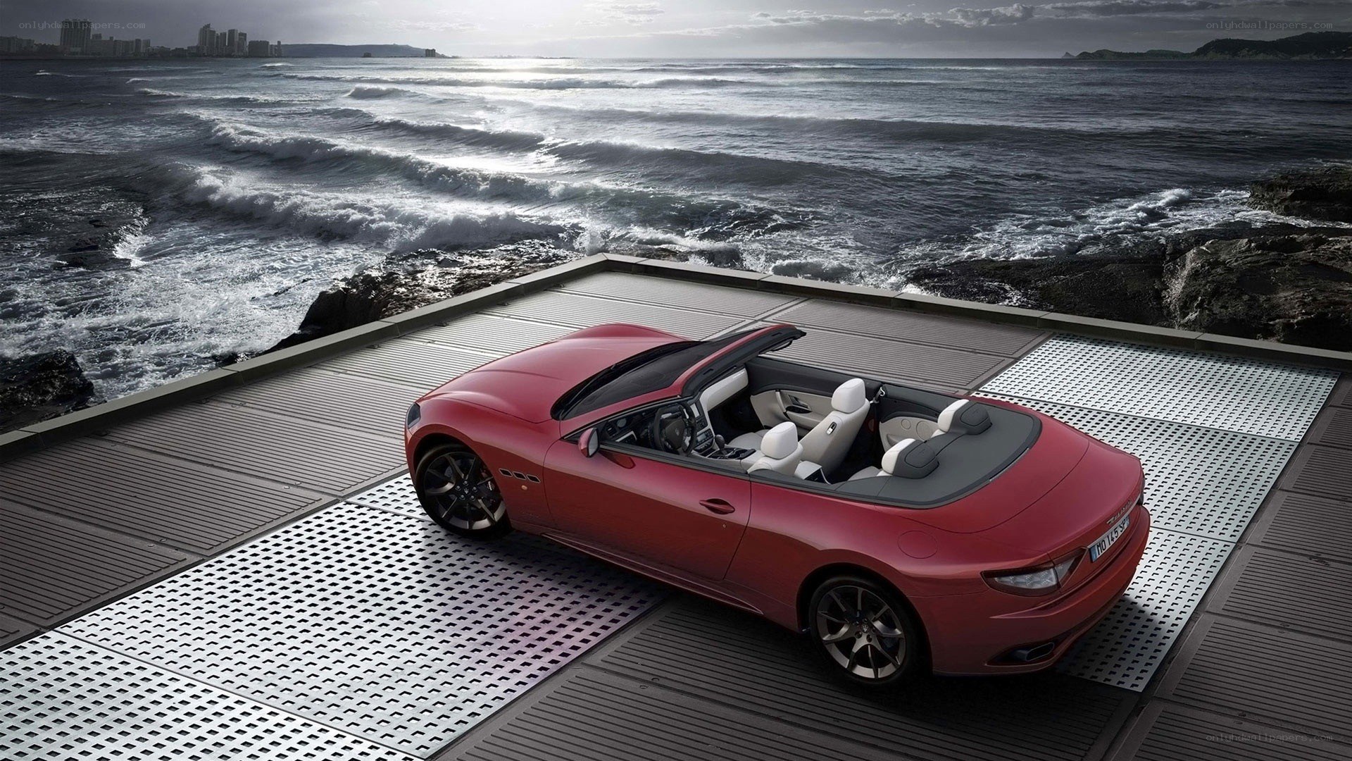 Red convertible on seaside platform