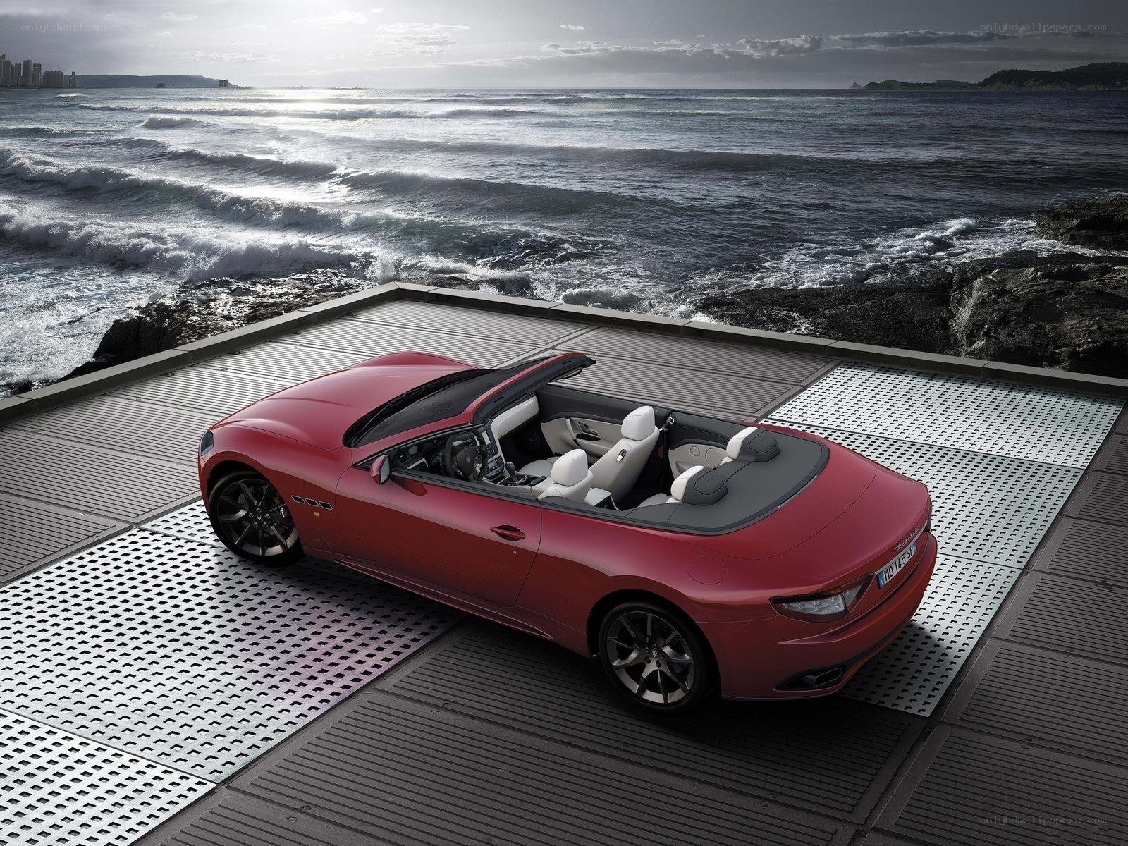 Red convertible on seaside platform