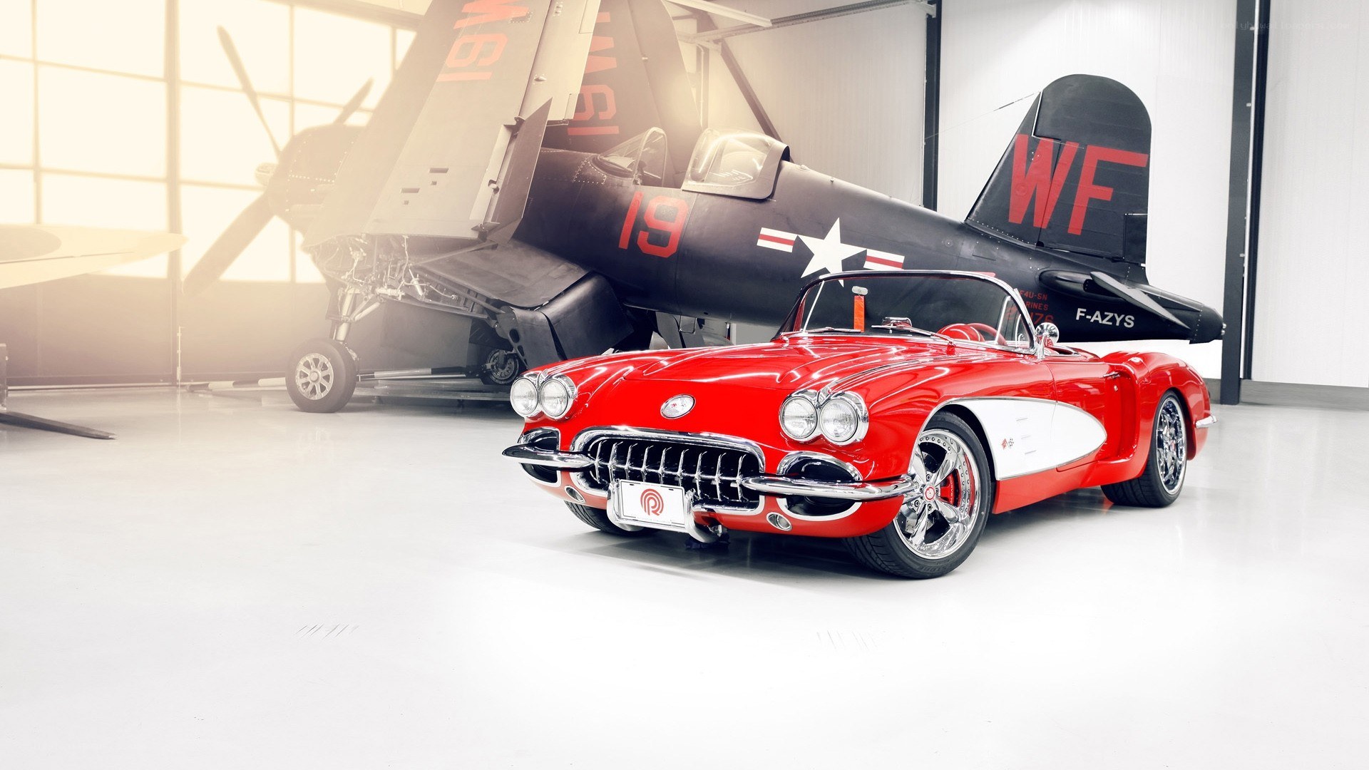 Red Corvette and vintage plane