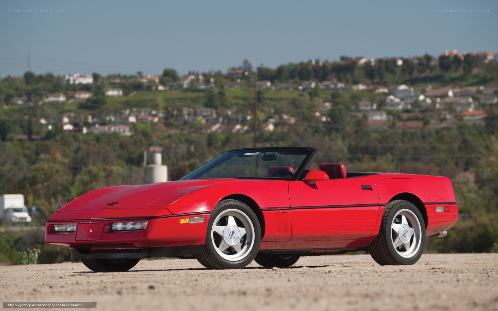Red Corvette convertible on dirt
