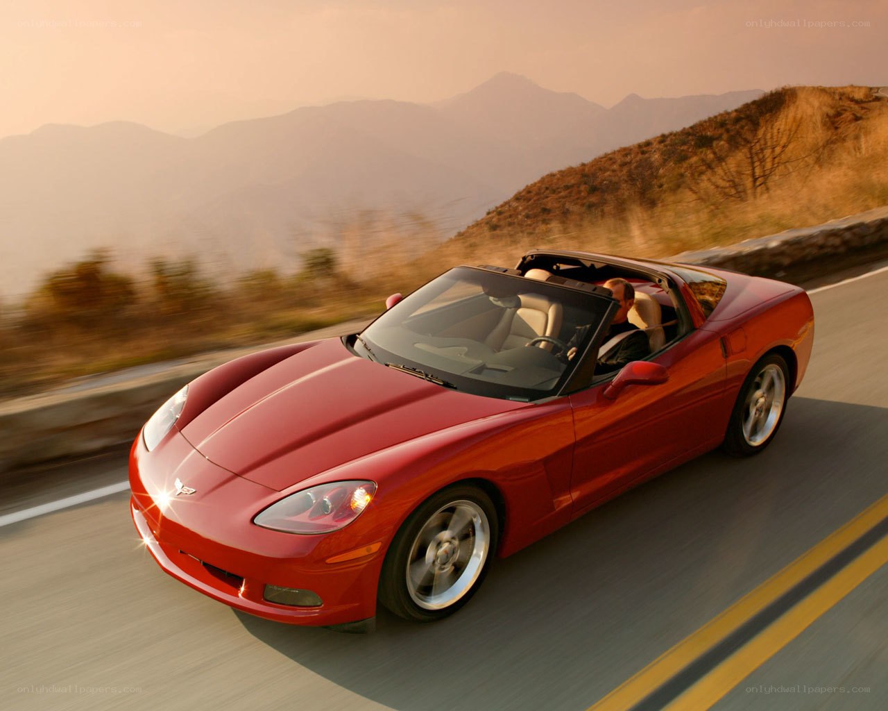 Red Corvette convertible on mountain road