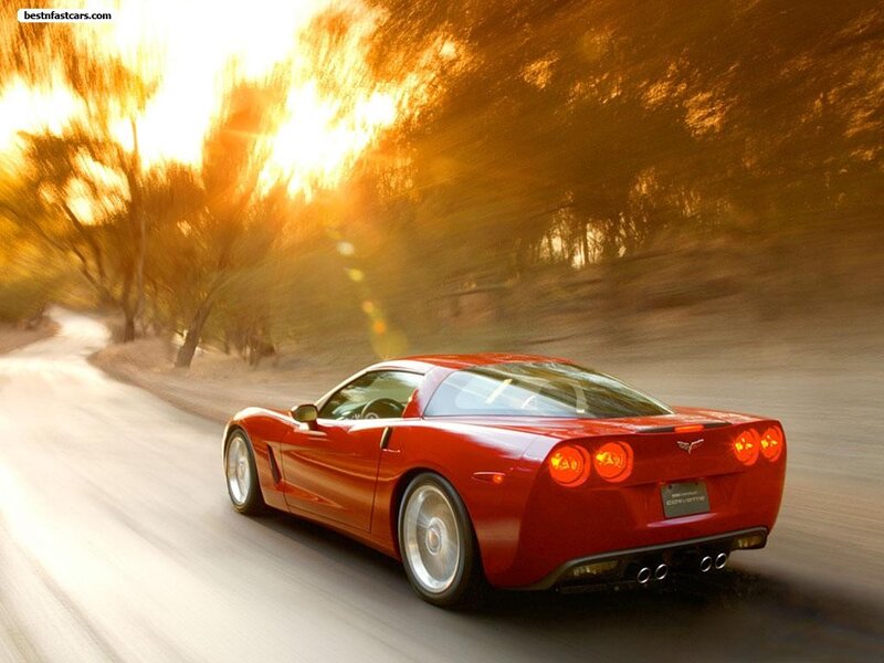 Red Corvette driving on a road