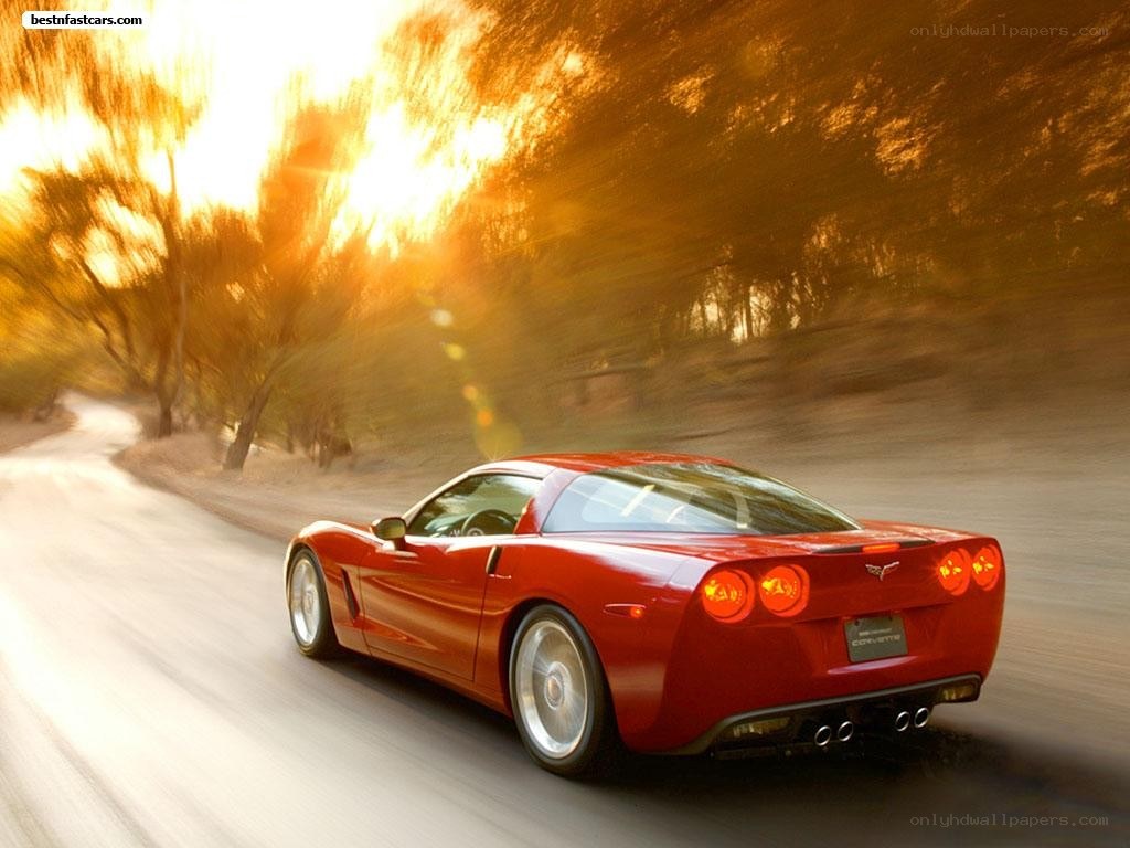 Red Corvette driving on a road