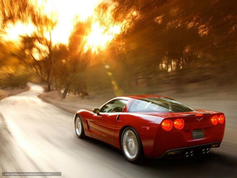 Red Corvette driving on road