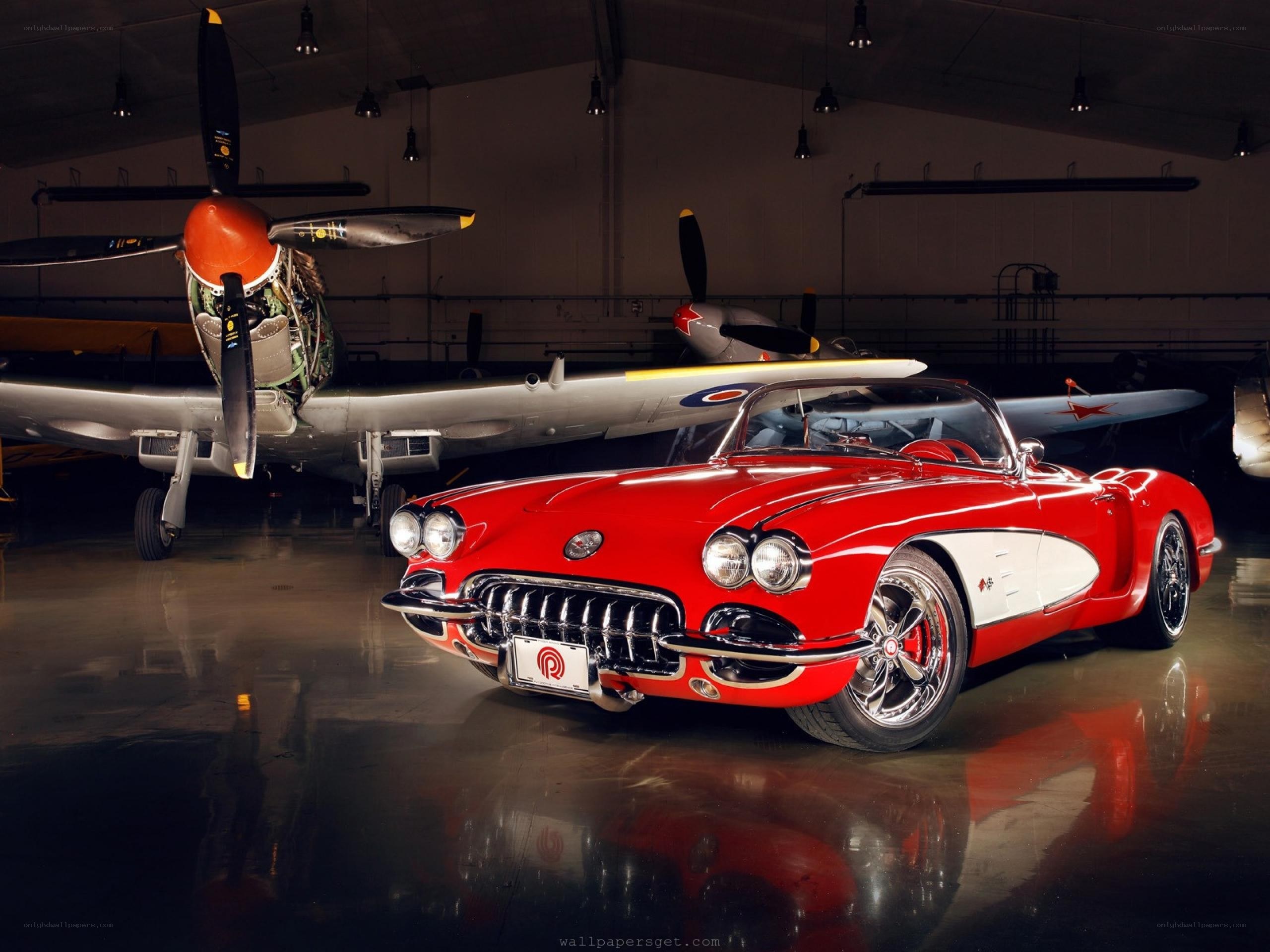 Red Corvette in aircraft hangar