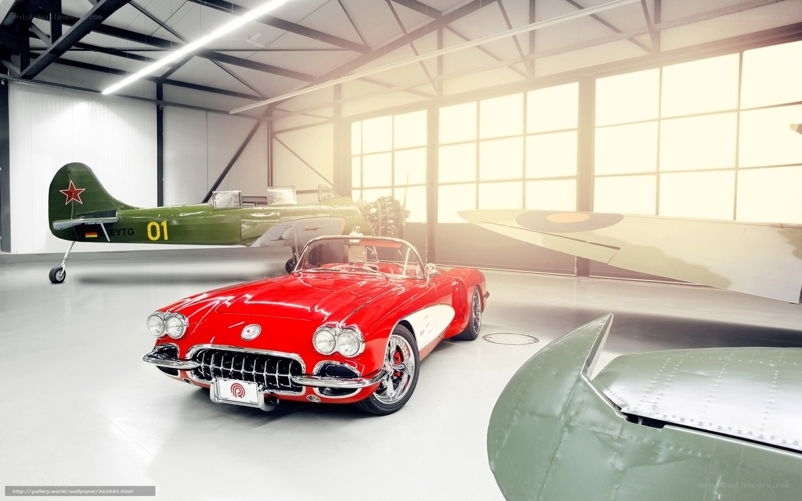Red Corvette in aircraft hangar