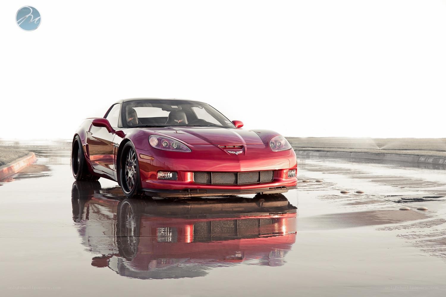 Red Corvette on wet pavement