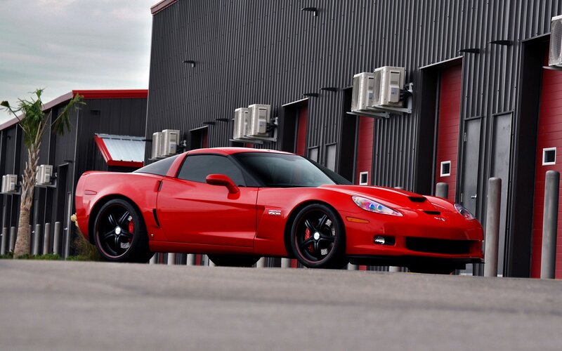Red Corvette parked outside building