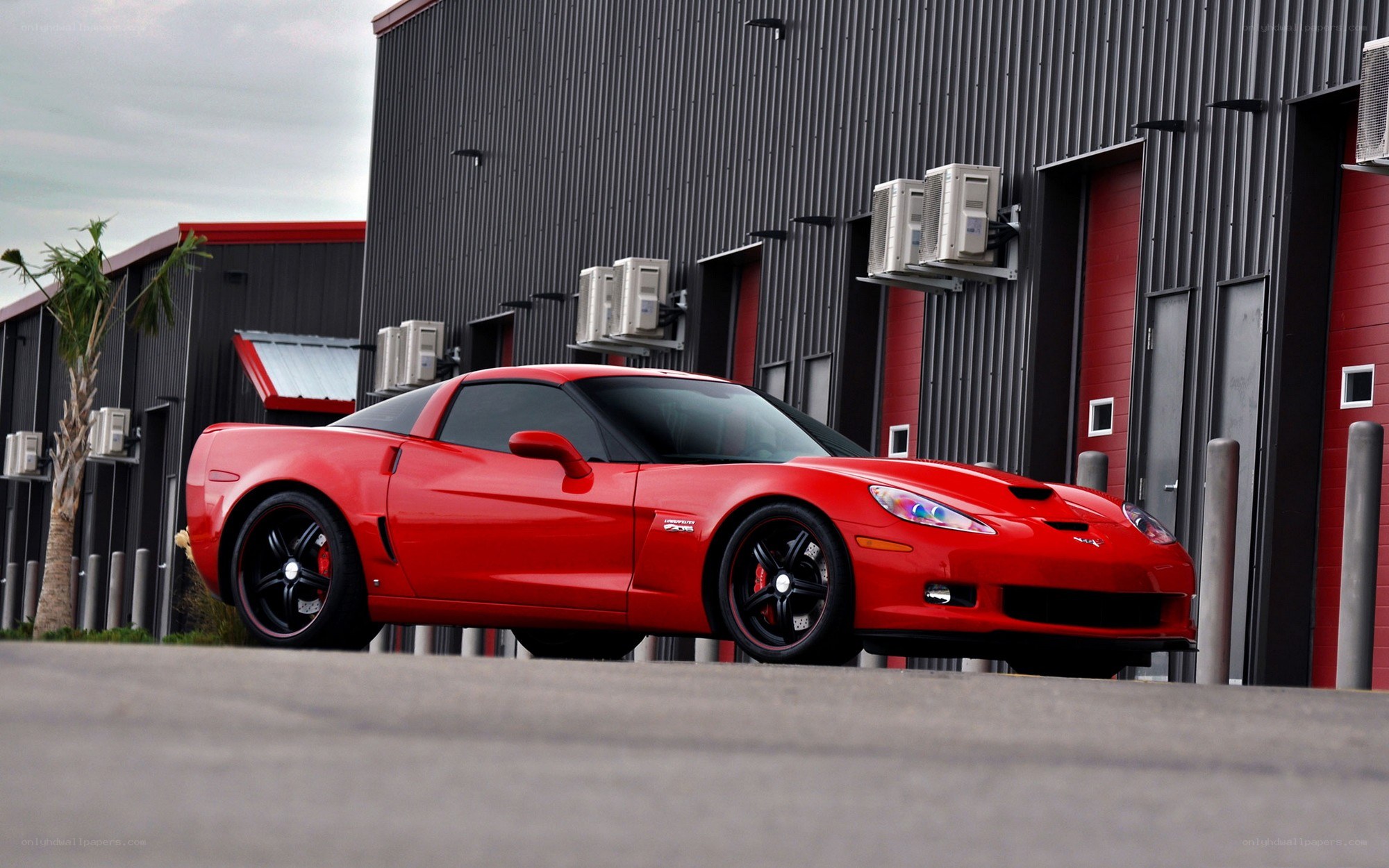 Red Corvette parked outside building