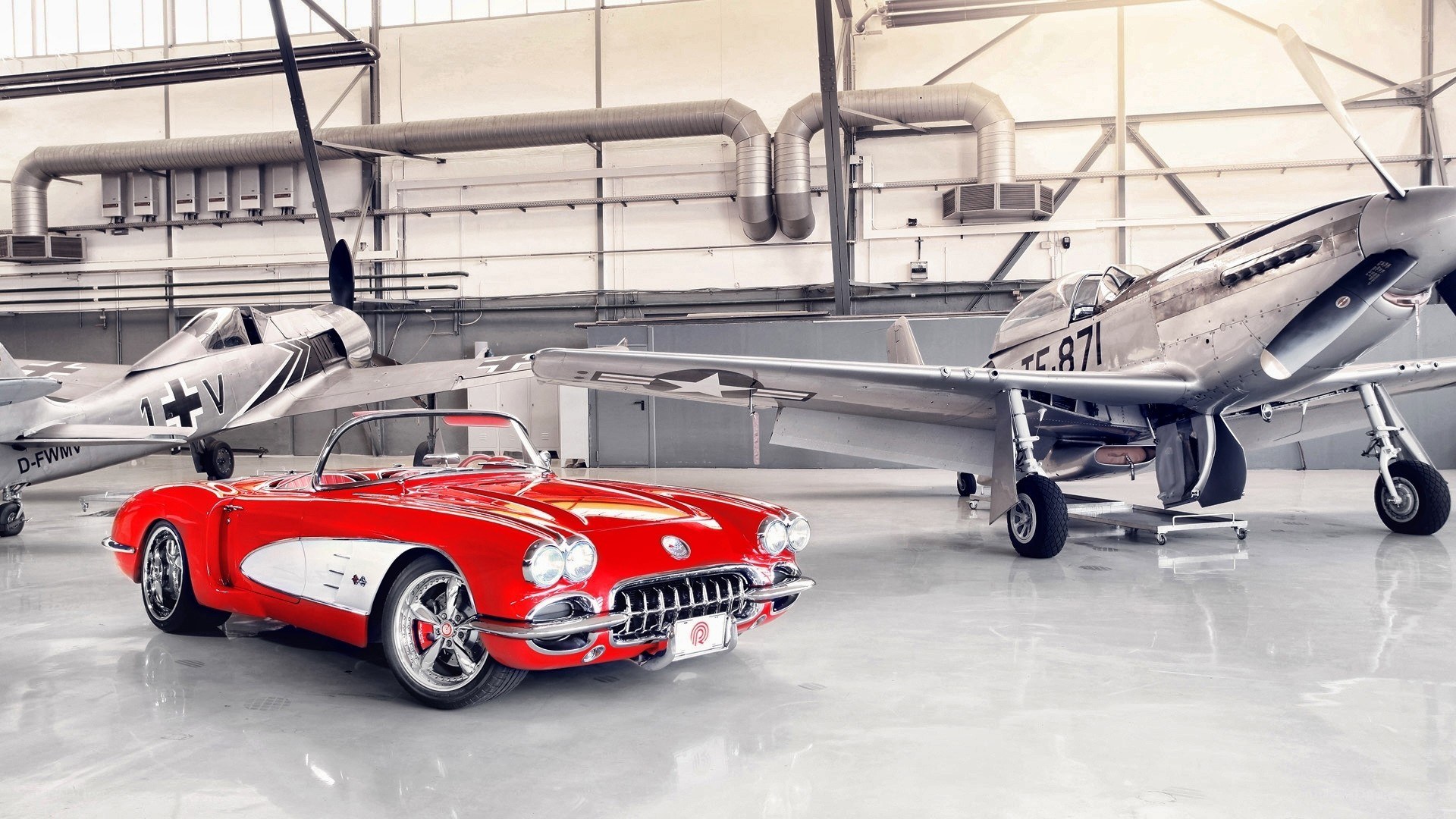 Red Corvette with vintage planes