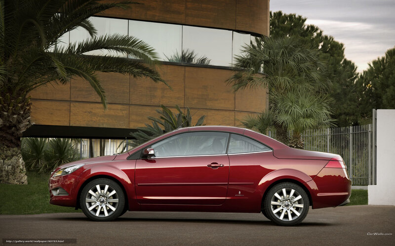 red coupe car in front of modern building